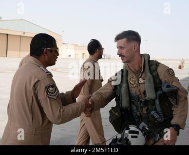 A U.S. Marine Corps F/A-18 Hornet pilot assigned to the Marine Fighter Attack Squadron 115 shake hands with a Royal Saudi Air Force member at King Faisal Air Base, Saudi Arabia, in support of Operation Agile Spartan II March 9, 2022. OAS II is focused on operational test and evaluation of Agile Combat Employment competencies developed by Ninth Air Force (Air Forces Central) headquarters, individual Air Expeditionary Wings, sister services, and our partner nations through multiple theater-wide events. Stock Photo