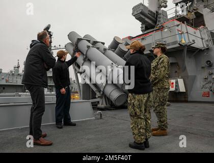 NORFOLK, Va. (Mar. 10, 2022) – Ensign Nicholas Lumalcuri, center left, gives a tour of the aft missile deck while aboard the Arleigh Burke-class guided-missile destroyer USS Porter (DDG 78), Mar. 10, 2022. Porter, forward-deployed to Rota, Spain, is currently underway in the U.S. 2nd Fleet area of operations to conduct routine certifications and training. Stock Photo