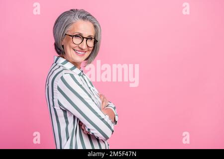 Side profile photo of optimistic successful manager business lady crossed hands look you wear striped shirt promo isolated on pink color background Stock Photo