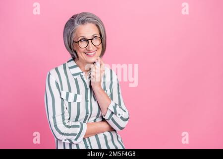 Photo of charming dreamy lady wear smart casual clothes smiling looking empty space isolated pink color background Stock Photo