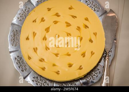 Beautiful mango cake with small mango heart decorations served on a silver tray. Stock Photo