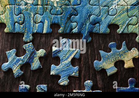 Blue and yellow puzzle being put together Stock Photo