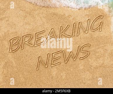Concept or conceptual Breaking News handwritten text in sand on a beach with waves in exotic island for adventure, summer, ocean, sea, travel, Stock Photo