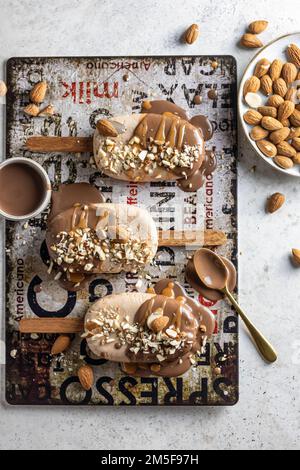 A few delicious homemade vegan ice cream bars or popsicles covered with chocolate and nuts top view, flat lay. Vertical Stock Photo