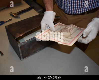 Courtney Burns, director of the New York State Military Museum, examines an issue of  an African-American publication called “The National Review” found inside a  time capsule discovered inside the cornerstone of the original section of the New York National Guard’s historic Harlem Armory during renovation work. The box, which was not known to be in the corner stone, contained documents pertaining to the 369th “Harlem Hell Fighters” or World War I fame, as well as documents of importance to the Black community in 1923 New York City. Stock Photo