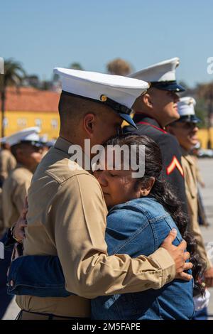 A new U.S. Marine of Echo Company, 2nd Recruit Training Battalion, is welcomed by a loved one following a graduation ceremony at Marine Corps Recruit Depot San Diego, March 11, 2022. Once Echo Company was dismissed, families and friends met their new Marines on the parade deck. Stock Photo