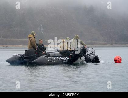 Navy explosive ordnance disposal technicians assigned to Explosive Ordnance Disposal Mobile Unit (EODMU) 1 perform a silent water entry as part of their mission to reacquire, identify and neutralize inert mine shapes in the Gastineau Channel near Juneau, Alaska, March 11, 2022, during Exercise ARCTIC EDGE 2022 (AE22). AE22 is a defensive exercise for U.S. Northern Command and Canadian Armed Forces designed to demonstrate and exercise our ability to rapidly deploy and operate in the Arctic. Stock Photo
