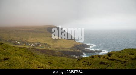 Mykines village by the sea between the grass fields seen from Mykineshólmur Stock Photo