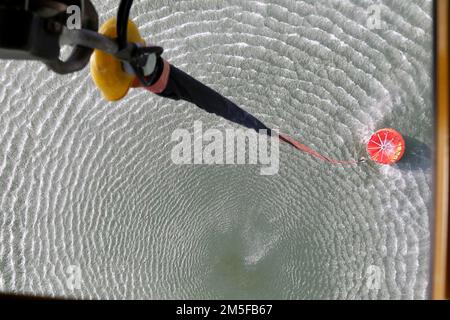 Water fills in a bambi bucket attached to a CH-47 Chinook helicopter in the Kach’ang-josuji water reservoir to be used in fighting wildfires. Stock Photo