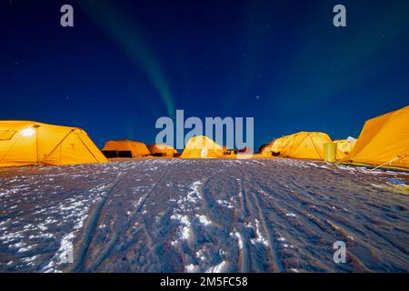 BEAUFORT SEA, Arctic Circle (March 11, 2022) – The Northern Lights illuminate the Arctic sky over the Navy's Ice Camp Queenfish during Ice Exercise (ICEX) 2022. Ice Camp Queenfish is built on a sheet of floating ice approximately 160 nautical miles offshore in the Arctic Ocean, and includes sleeping tents for about 60 personnel, a command center, dining tent and runway for aircraft. ICEX 2022 is a three-week exercise that allows the Navy to assess its operational readiness in the Arctic, increase experience in the region, advance understanding of the Arctic environment, and continue to develop Stock Photo