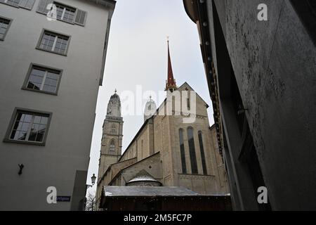 The Grossmünster captured in low angle view. It is shot between two nearby historic buildings. Stock Photo