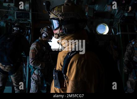 A Polish Special Forces Operator prepares to jump from a U.S. Air Force MC-130J Commando II assigned to the 352d Special Operations Wing over Poland, March 11, 2022. Training with our joint and combined allies and partners increases our lethality and enhances interoperability, allowing our forces to counter military aggression and coercion by sharing responsibilities for common defense. Stock Photo