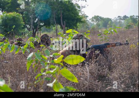 A squad of Beninese soldiers from the 1st Commando Parachute Battalion take cover to return fire during simulated ambush training in Ouassa, Africa, March 11, 2022. U.S. engagement comes with mutual benefit, upholds international norms, and treats partners as equals. Stock Photo