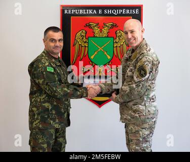 Albanian Land Forces Commander Brigadier General Arben Kingji provides a gift to U.S. Special Operations Command Europe commander Maj. Gen. David Tabor at the Albanian Special Forces Headquarters in Albania, March 11th, 2022. Special Operations Command Europe recently made the decision to locate a forward-based SOF headquarters, on a rotational basis, in Albania with the HQ being focused on SOF command and control of SOCEUR’s engagements in the region, coordination of Joint Combined Exchange Training engagements, and Civil Military Support Element engagement planning. Stock Photo