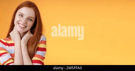 Silly enthusiastic attractive redhead blue-eyed girl tilting head touching neck flirty smiling enjoy perfect day feel happiness joy giggling Stock Photo