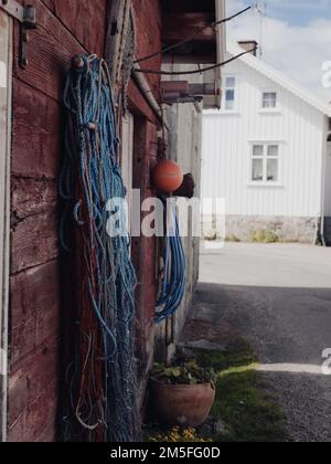 A vertical of fishing nets hanging from a wooden house wall from outside Stock Photo