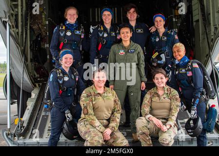 U.S. Air Force Wings of Blue and Airmen from the 71st Rescue Squadron pose for a photo for Women in Aviation Week behind an HC-130J Combat King II at Moody Air Force Base, Georgia, March 12, 2022. The Wings of Blue parachute team, assigned to the 98th Flying Training Squadron, Air Education and Training Command, participated in Moody AFB’s Youth Open House, a culminating event for Women In Aviation Week aimed to connect a younger generation to Airmen and inspire them for careers in airpower leading to a more diverse and effective Air Force in the future.. Stock Photo