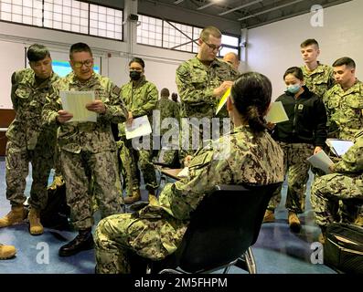 NEW YORK (MARCH 11, 2022) U.S. Navy Boatswains Mate 1st Class Tito Figueroa of Bronx NY, left center, reads names on a list of Sailors as part of Mass Activation Exercise 2022-1 (MAX 22-1), at Navy Reserve Center New York. About 200 Sailors practiced large group mobilization at NRC NYC over the drill weekend. Figueroa said,'We're getting the experience now. If we're mobilized for real, it will be a lot smoother.'     In February U.S. Navy Reserve leadership directed several large reserve centers on the East coast to develop, test and evaluate a new method of mobilizing Sailors in large numbers Stock Photo