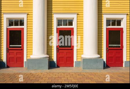 Red doors. Three coloured front doors at the entrance of an old historic house with columns. Travel photo, nobody, street photo Stock Photo