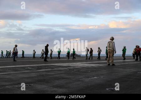 PHILIPPINE SEA (March 13, 2022) Sailors conduct a foreign object debris (FOD) walk down on the flight deck of the Nimitz-class aircraft carrier USS Abraham Lincoln (CVN 72). Abraham Lincoln Strike Group is on a scheduled deployment in the U.S. 7th Fleet area of operations to enhance interoperability through alliances and partnerships while serving as a ready-response force in support of a free and open Indo-Pacific region. Stock Photo