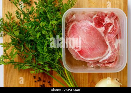 A delicious dish made with raw pork chops and herbs. Stock Photo