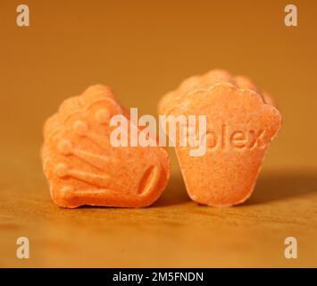 Orange pills with mdma ecstasy dope rolex drug close up background fine art in high quality prints Stock Photo