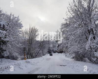 Canadian snow scene the week before Christmas. Recently plowed but still very snowy road in the Glebe, Ottawa, Canada. Stock Photo