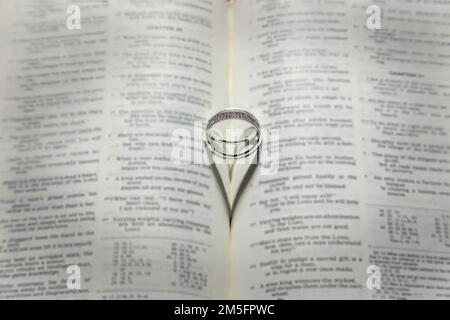 Wedding Rings with a heart shaped shadow on a Bible. Stock Photo