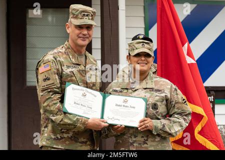 U.S. Army Maj. Gen. Charles Costanza, the 3rd Infantry Division commanding general, left, poses with Sgt. 1st Class Tania Sanchez, an East Hampton, New York, native and team leader assigned to the Noncommissioned Officer Academy, 3rd Infantry Division, with her reenlistment certificate at the NCO Academy on Fort Stewart, Georgia, March 15, 2022. Sanchez will remain in the military until she retires. Stock Photo