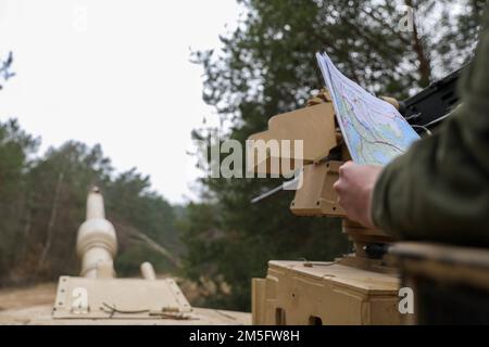 Spc. Austin Zink assigned to 2nd Battalion, 34th Armored Regiment, 1st Armored Brigade Combat Team, 1st Infantry Division, plots additional coordinates on the map after finding the first point during land navigation training  at Drawsko Pomorskie, Poland, March 15, 2022. Stock Photo