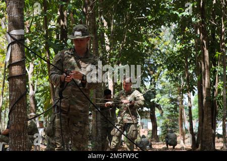 U.S. Army Pfc. Tristan Gilbert, an infantryman assigned to Headquarters and Headquarters Company, 2nd Battalion, 27th Infantry Regiment, 3rd Infantry Brigade Combat Team, 25th Infantry Division, prepares a one rope bridge for inspection during the Jungle Operations Training Course held at Salaknib 2022 on Fort Magsaysay, Nueva Ecija, Philippines, March 15, 2022. The Jungle Operations Training Course aimed to prepare soldiers from both the U.S. and the Philippines for the jungle terrain they may encounter around the Indo-Pacific, building on Salaknib’s mission of increasing combined readiness a Stock Photo