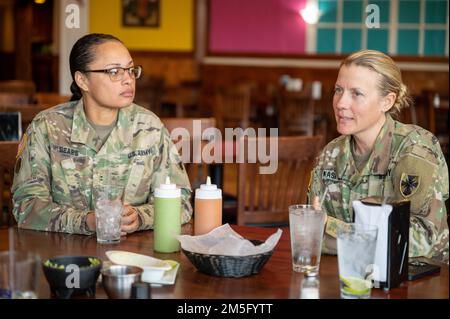 U.S. Army Chief Warrant Officer 2 Janice Sears, 605th Transportation Detachment Logistics Support Vessel-8 chief engineer, left, listens to CW2 Teresa Kasper, 163rd Transportation Detachment Logistics Support Vessel-4 2nd mate, during a lunch-in at Joint Base Langley-Eustis, Virginia, March 18, 2022. Several of the attendees shared their respective career experiences as well as ways to discuss spreading information about their MOS so others can reach out and gain a better understanding of this route in the Army. Stock Photo