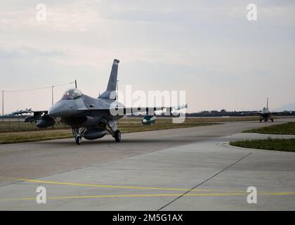 Two U.S. Air Force F-16C Fighting Falcon pilots assigned to the 555th Fighter Squadron from the 31st Fighter Wing, Aviano Air Base, Italy, taxi in after landing at Croatia’s 91st Air Base at Pleso, March 16, 2022. The 31st FW will execute routine Agile Combat Employment operations with Croatian Allies. Missions such as these enhance the readiness necessary to respond to any potential challenge in Southeast Europe. Stock Photo