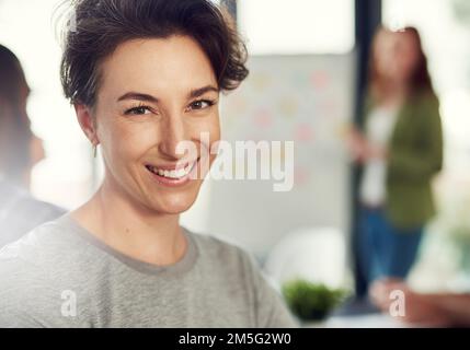 Im determined to succeed all the way. Portrait of a young businesswoman sitting in a modern office with her colleagues. Stock Photo