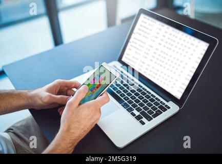 Managing his digital diary. Closeup shot of a young creative using a cellphone in a modern office. Stock Photo
