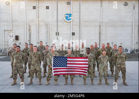 U.S. Air Force Reservists from the 944th Fighter Wing pose in front of the 380th Air Expeditionary Wing headquarters building at Al Dhafra Air Base, United Arab Emirates, March 16, 2022. The 944th is based at Luke Air Force Base, Arizona. The Reservists are working alongside active duty and Air National Guard Airmen to make up the 380th Air Expeditionary Wing at Al Dhafra. Stock Photo