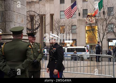 Sergeant McGilloway, with the Irish Defense Forces, 20th Infantry Battalion, left, speaks with U.S. Marine Capt. Frank P. Cinturati Jr., a special projects officer with 1st Marine Corps District, before the start of the New York City St. Patrick's Day Parade in New York, Mar. 17, 2022. The NYC St. Patrick’s Day Parade is held annually along Fifth Avenue to celebrate Irish heritage, commemorate those who died during the Sept. 11, 2001 terrorist attacks, and celebrate first responders and essential workers. Stock Photo