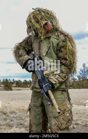 Staff Sgt. Aaron Lee, 341 Missile Security Operations Squadron, Malmstrom Air Force Base, Montana, demonstrates his ghillie suit during the Nuclear Advanced Designated Marksman course March 16, 2022 at Camp Guernsey, Wyoming. A proper ghillie suit is imperative to helping a sniper stay hidden from his adversaries. Stock Photo