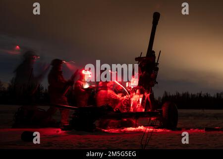 U.S. Army paratroopers with Bravo Battery, 2nd Battalion, 377th Parachute Field Artillery Regiment, 4th Infantry Brigade Combat Team (Airborne), 25th Infantry Division, U.S. Army Alaska, set off an M119 105mm howitzer during artillery live-fire training at Joint Base Elmendorf-Richardson, Alaska, March 16, 2022. USARAK trains year-round in an arctic environment to prepare for real-world combat missions, and uses artillery live-fire training to strengthen and hone artillery skills. Stock Photo