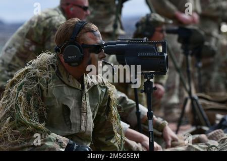 Staff Sgt. Aaron Lee, 341 Missile Security Operations Squadron, Malmstrom Air Force Base, Montana, spots the target for his sniper counterpart during the Nuclear Advanced Designated Marksman course March 16, 2022 at Camp Guernsey, Wyoming. A spotter tracks the sniper's shot by watching for the bullet's vapor trail then helps the sniper readjust their shot. Stock Photo