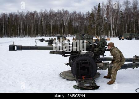 U.S. Army paratroopers assigned to Bravo Battery, 2nd Battalion, 377th Parachute Field Artillery Regiment, 4th Infantry Brigade Combat Team (Airborne), 25th Infantry Division, U.S. Army Alaska, stage for live-fire artillery training at Joint Base Elmendorf-Richardson, Alaska, March 16, 2022. The Soldiers of 4/25 belong to the only American airborne brigade in the Pacific and are trained to execute airborne maneuvers in extreme cold weather and high altitude environments in support of combat, partnership and disaster relief operations. Stock Photo