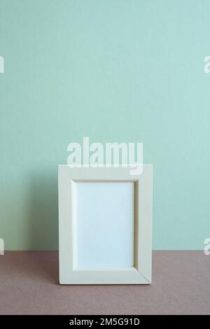 Blank picture frame on table. mint wall background. copy space Stock Photo