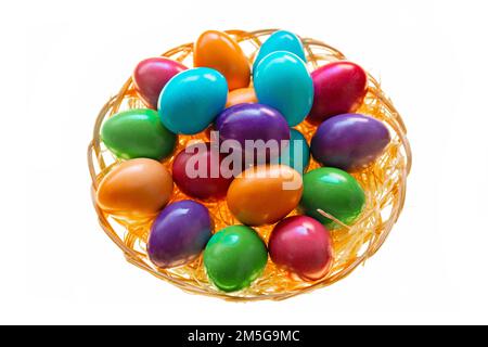 Easter multicolored painted eggs in a wicker bowl on a white background.Easter food. Spring religious holiday symbol. Easter tradition. Christian and Stock Photo