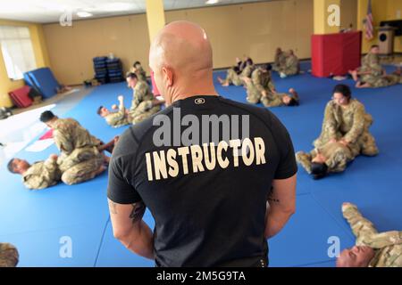 U.S. Air Force Master Sgt. Brian Cantu, an Air Force senior combatives instructor, with the 621st Contingency Response Squadron, Joint Base Mcguire-Dix-Lakehurst, oversees Airmen practice grappling techniques, March 16, 2022 at Muñiz Air National Guard Base, Puerto Rico. The 22 newly graduated Air Force Combatives instructors, all from different sections of the 156th Wing can pass down the knowledge they’ve acquired to other Airmen and assist in developing an always ready fighting force. “For us as instructors, just being able to see the Airmen grow in the aspect of having a mentality of ‘You Stock Photo