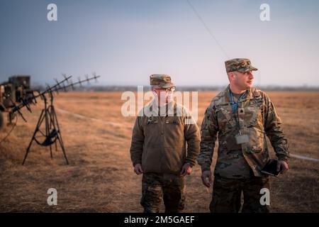 Maj. Gen. Greg Brady, commanding general of the 10th Army Air and Missile Defense Command and Lt. Col Steven Rachamim, commander of the 5th Battalion, 7th Air Defense Artillery Regiment, survey the battalion’s operations in Poland during a site visit by the 10th AAMDC command team on March 16, 2022. Stock Photo