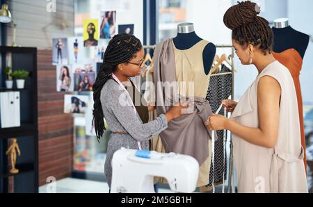 Under promise and over deliver. two young designers collaborating on a new design. Stock Photo