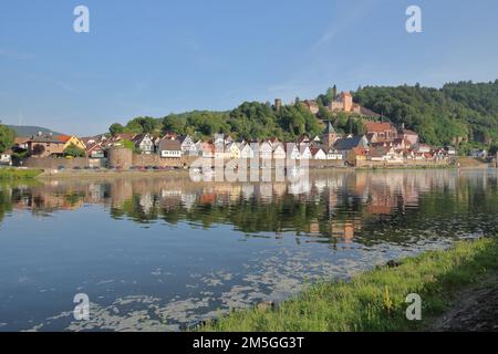 View of townscape with castle, churches and town fortification of Hirschhorn with reflection in Neckar river, Neckar valley, Odenwald, Hesse, Germany Stock Photo