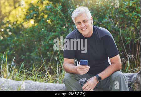 Senior runner man, music and rest in nature portrait, smile or smartphone for workout, exercise or health. Happy elderly guy, phone and streaming Stock Photo