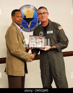 220317-N-N0443-0006 PENSACOLA, Fla. (Mar. 17, 2022) Rear Adm. Pete Garvin, commander of Naval Education and Training Command, presents a plaque to Mr. Eric Green, a human resources specialist for Military Manning (N122) in Pensacola, Fla., during a hybrid award ceremony in the NETC headquarters aboard Naval Air Station Pensacola Mar. 17. Green received the plaque and a Navy Civilian Service Achievement Medal for being selected as the NETC senior civilian of the quarter for first quarter fiscal year (FY) 2022. Stock Photo