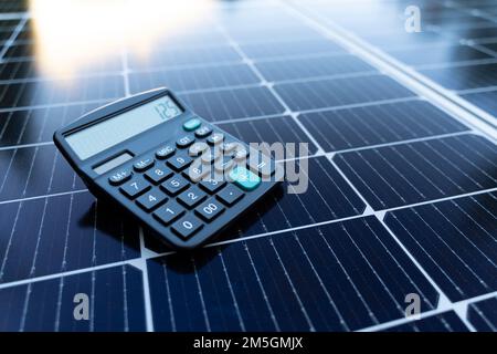 Energy saving concept with solar panels and a calculator Stock Photo